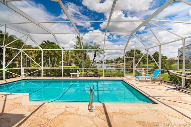 outdoor pool featuring glass enclosure and a patio