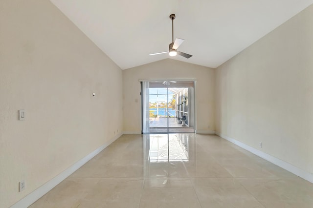 empty room featuring a ceiling fan, lofted ceiling, baseboards, and light tile patterned floors