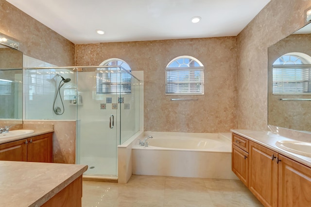 full bathroom featuring a sink, two vanities, a shower stall, and a bath