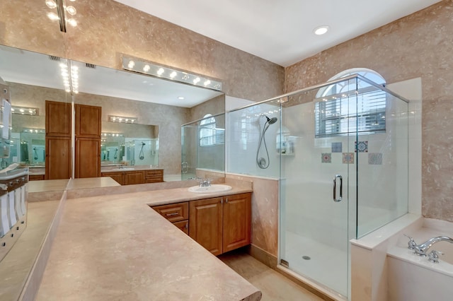 full bath featuring a garden tub, two vanities, a sink, and a shower stall