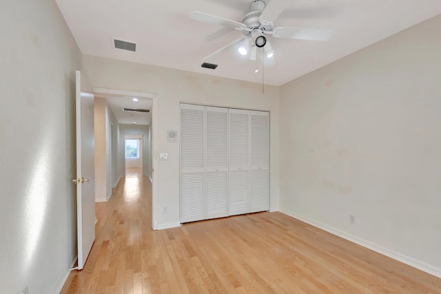 unfurnished bedroom with a closet, visible vents, light wood-style flooring, ceiling fan, and baseboards