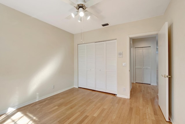 unfurnished bedroom with a ceiling fan, baseboards, visible vents, light wood-style floors, and a closet