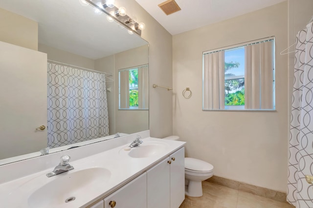 full bath with toilet, double vanity, a sink, and visible vents