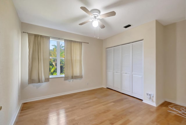 unfurnished bedroom featuring light wood-style floors, visible vents, baseboards, and a closet