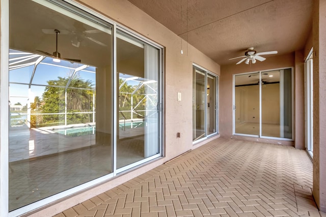 unfurnished sunroom featuring ceiling fan