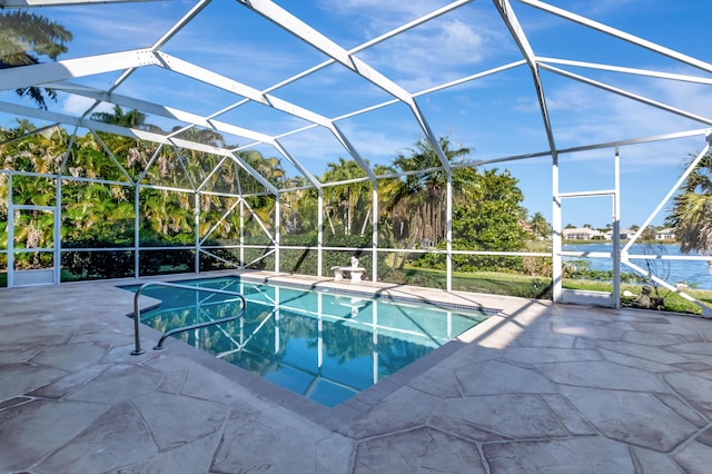 pool featuring glass enclosure, a patio, and a water view