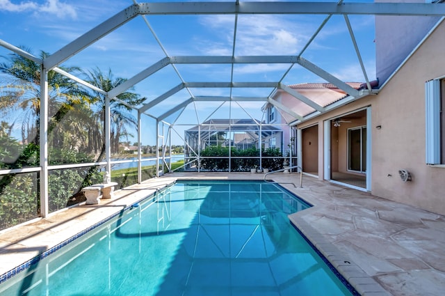 pool with a ceiling fan, a patio area, and glass enclosure