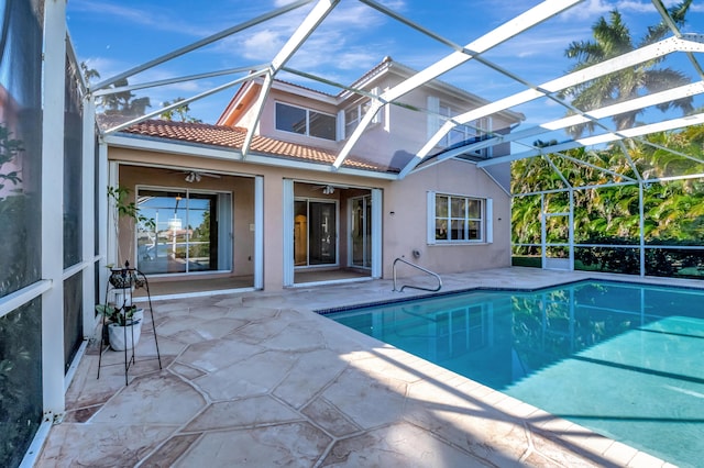 pool featuring ceiling fan, glass enclosure, and a patio area