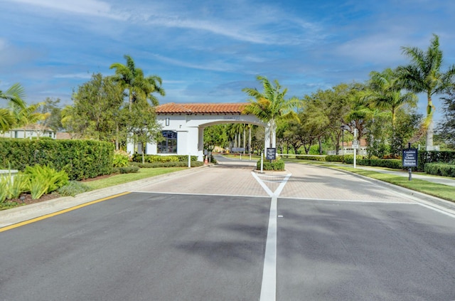 view of road with curbs and a gated entry