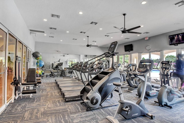 gym with carpet floors, visible vents, and a textured ceiling