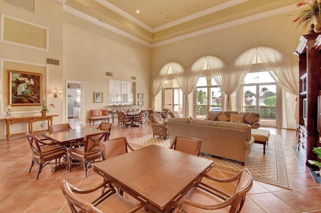 dining room featuring visible vents, crown molding, a towering ceiling, and light tile patterned floors