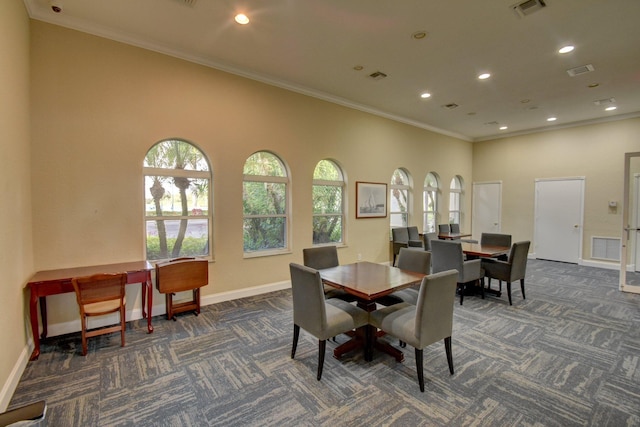 dining area featuring plenty of natural light, visible vents, and dark carpet