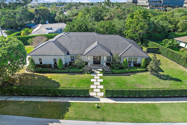 view of front of house with a tiled roof and a front lawn