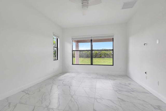 empty room with marble finish floor, baseboards, and visible vents