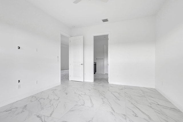 spare room with marble finish floor, baseboards, ceiling fan, and visible vents