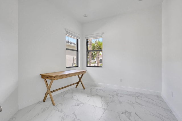 unfurnished room with baseboards and marble finish floor