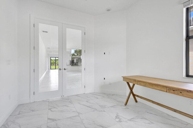 interior space featuring visible vents, baseboards, french doors, and marble finish floor