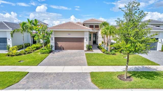 view of front of home featuring a front yard, stucco siding, an attached garage, decorative driveway, and a tile roof