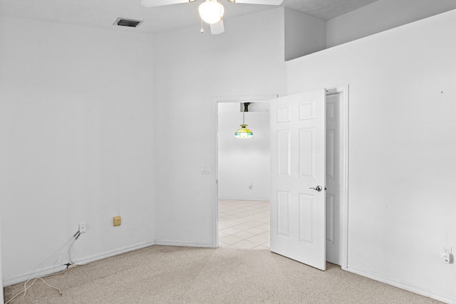 1820 SE Hideaway Cir Unit 1820, Port Saint Lucie, FL 34952 - empty room featuring light colored carpet, light tile patterned floors, baseboards, visible vents, and a ceiling fan