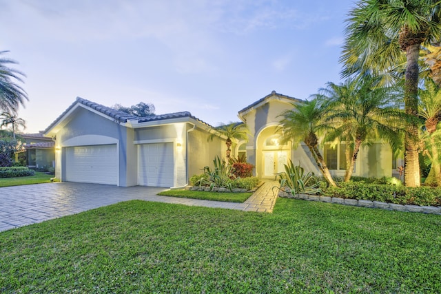 mediterranean / spanish-style house with a front lawn and a garage