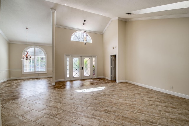 foyer entrance featuring high vaulted ceiling, a notable chandelier, baseboards, french doors, and crown molding