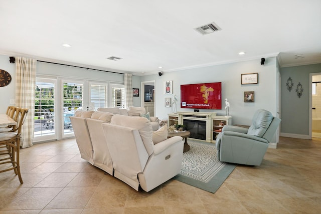 living area with a glass covered fireplace, visible vents, crown molding, and recessed lighting