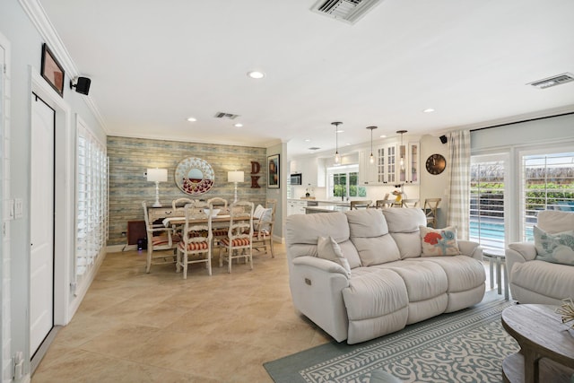 living room featuring ornamental molding, recessed lighting, and visible vents