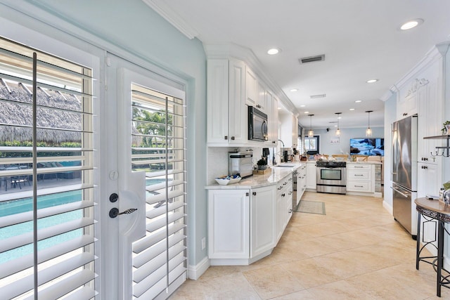 kitchen with visible vents, a peninsula, ornamental molding, white cabinets, and appliances with stainless steel finishes