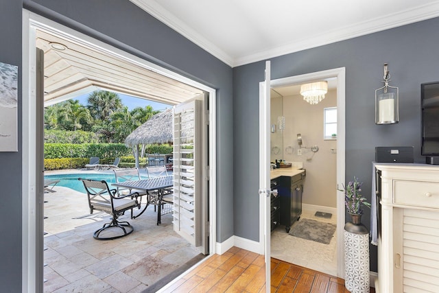 interior space featuring wood finished floors, baseboards, and ornamental molding