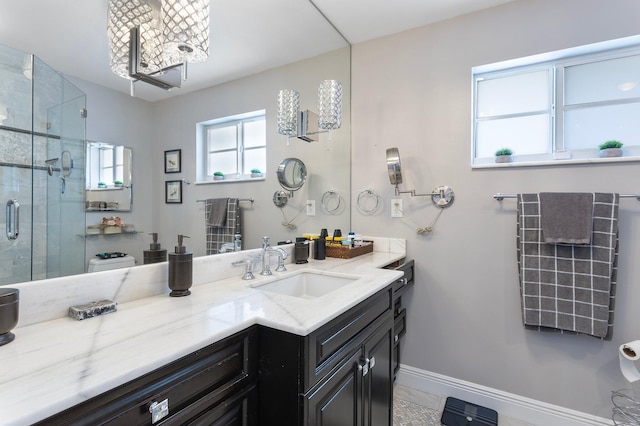 full bathroom with a shower stall, vanity, and baseboards
