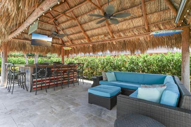 view of patio / terrace with ceiling fan, an outdoor living space, outdoor dry bar, and a gazebo