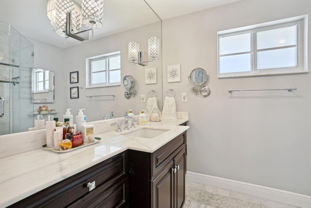 bathroom featuring baseboards, vanity, and a shower stall