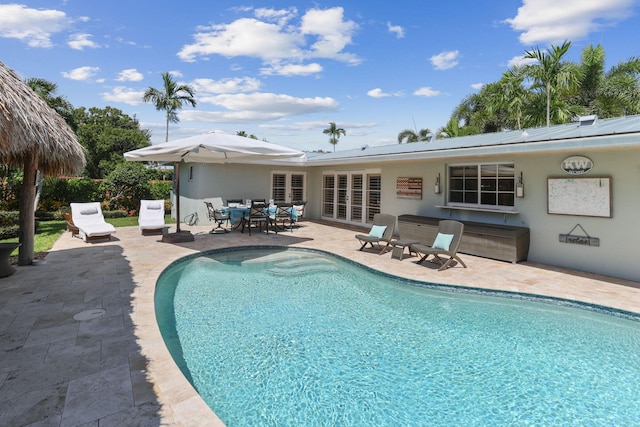 view of pool with a patio area, a fenced in pool, and french doors