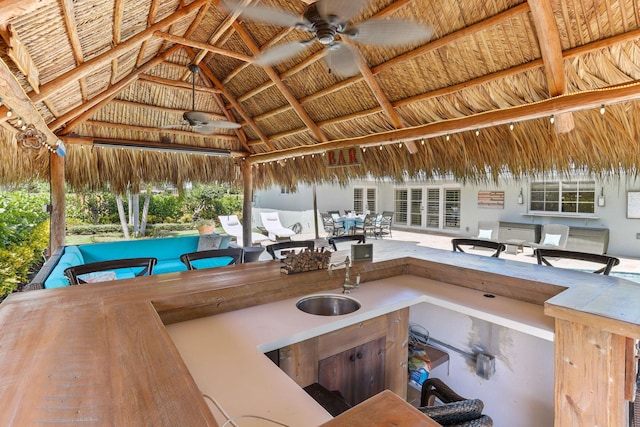 view of patio featuring a gazebo, outdoor dining space, ceiling fan, and a sink