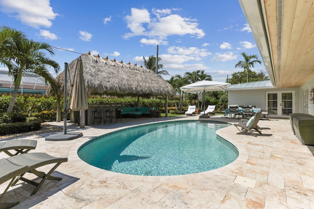 outdoor pool with outdoor dry bar, a patio, a gazebo, french doors, and an outdoor hangout area