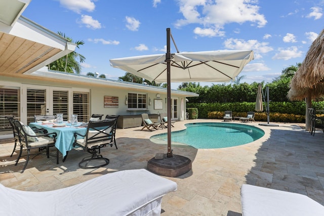pool with outdoor dining area and a patio
