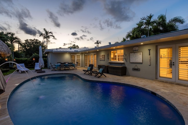 view of swimming pool with a patio, outdoor dining area, and french doors
