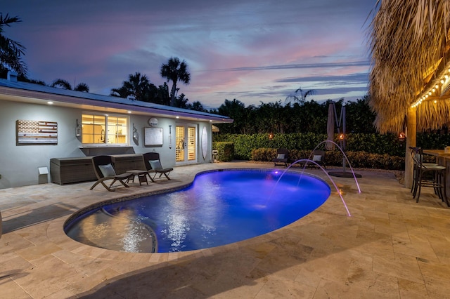 outdoor pool with a patio area, french doors, and outdoor dry bar