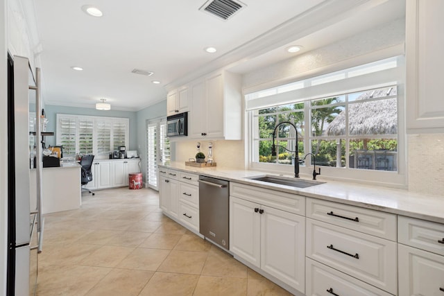 kitchen with visible vents, stainless steel appliances, crown molding, white cabinetry, and a sink