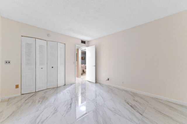 1024 Ellesmere B, Deerfield Beach, FL 33442 - unfurnished bedroom with a textured ceiling and a closet