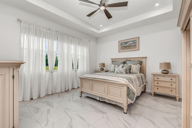 bedroom with ceiling fan, marble finish floor, a raised ceiling, and recessed lighting