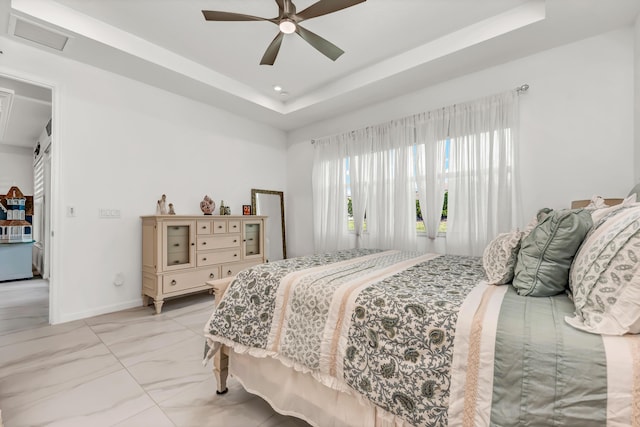 bedroom with ceiling fan, visible vents, baseboards, marble finish floor, and a tray ceiling