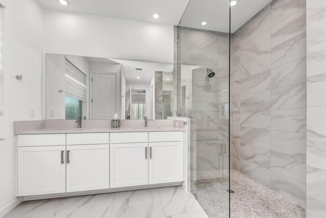 full bathroom featuring marble finish floor, double vanity, a sink, and walk in shower