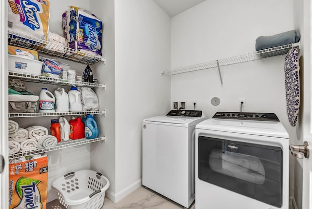 laundry room with laundry area, baseboards, marble finish floor, and washer and clothes dryer