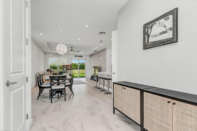 dining area with visible vents, marble finish floor, a tray ceiling, a chandelier, and recessed lighting