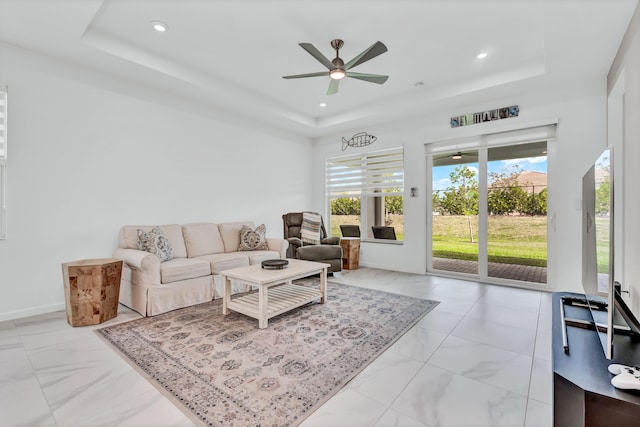 living room featuring a raised ceiling and recessed lighting