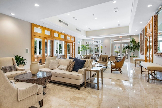 living room featuring a tray ceiling and french doors