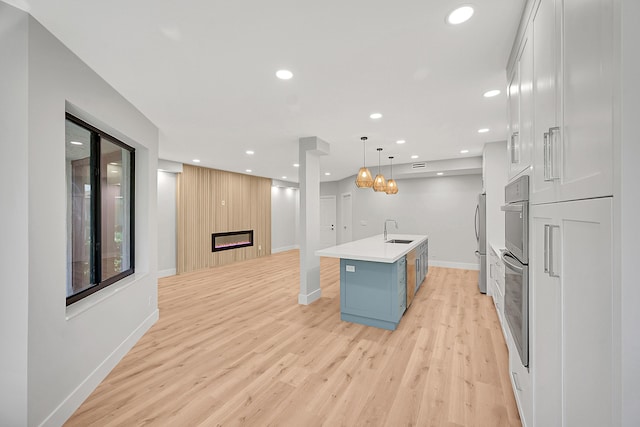 303 Sea Oats Dr Unit D, Juno Beach, FL 33408 - kitchen with a sink, light wood finished floors, recessed lighting, baseboards, and freestanding refrigerator