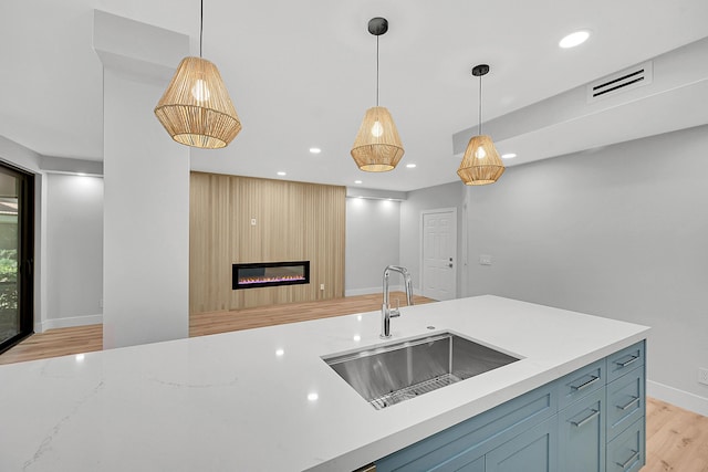 303 Sea Oats Dr Unit D, Juno Beach, FL 33408 - kitchen with a sink, light wood-style flooring, decorative light fixtures, recessed lighting, and a large fireplace
