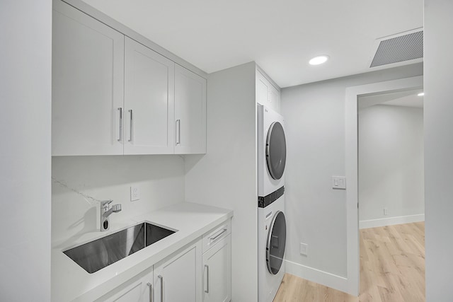 303 Sea Oats Dr Unit D, Juno Beach, FL 33408 - washroom with estacked washer and dryer, cabinet space, light wood-style flooring, baseboards, and recessed lighting